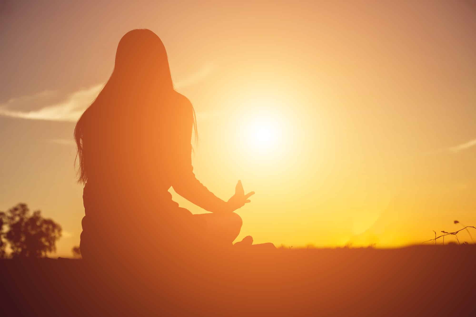 Donna in meditazione al tramonto durante il weekend costellazioni familiari Trieste a Punto Zero